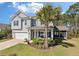 Charming two-story home boasts a well-maintained lawn, inviting front porch, and attached two car garage at 4021 Brown Trout Dr, Johns Island, SC 29455