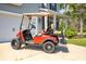 Red golf cart parked in driveway, showcasing easy access to community amenities and local attractions at 4021 Brown Trout Dr, Johns Island, SC 29455