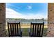 View of the lake from the porch with two rocking chairs, providing a peaceful and scenic place to unwind at 4021 Brown Trout Dr, Johns Island, SC 29455
