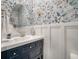 Chic powder room with bee-themed wallpaper, round mirror, and blue vanity at 4021 Brown Trout Dr, Johns Island, SC 29455