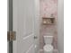 Cozy powder room featuring floral wallpaper and stylish shelving with decor at 4021 Brown Trout Dr, Johns Island, SC 29455