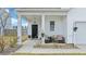 Inviting front porch with comfortable seating, decorative plants, and a stylish black front door at 429 Pender Woods Dr, Summerville, SC 29486