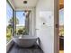 Modern bathroom featuring a freestanding tub, large window with view, and stylish pendant lighting at 430 Fish Tale Rd, Charleston, SC 29492