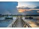 Charming gazebo and boat dock with a view of distant houses and a sunset peeking through the clouds at 430 Fish Tale Rd, Charleston, SC 29492