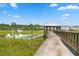 Picturesque waterfront view with a boat docked, seen from a wooden pier under a sunny sky at 430 Fish Tale Rd, Charleston, SC 29492