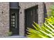 Classic brick home featuring a glass door entry, black garage door, and beautiful greenery enhancing curb appeal at 430 Fish Tale Rd, Charleston, SC 29492