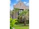 Charming brick home with lush landscaping, palm trees, and manicured lawn creating curb appeal at 430 Fish Tale Rd, Charleston, SC 29492