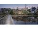 Lush view of a brick home with black trim reflected in the water, accessed by a private wooden dock at 430 Fish Tale Rd, Charleston, SC 29492