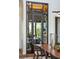 View of wine cellar behind a black-trimmed glass door, adjacent to a wooden dining table at 430 Fish Tale Rd, Charleston, SC 29492