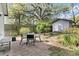 Backyard patio offers a tranquil space with outdoor seating, mature trees, and a detached shed at 4445 Old Park Rd, North Charleston, SC 29405