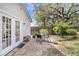Backyard patio with ample seating, mature trees creating a relaxing outdoor oasis next to a white home at 4445 Old Park Rd, North Charleston, SC 29405