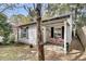 Charming home exterior with a cozy front porch, a small table with two red chairs and blooming plants at 4445 Old Park Rd, North Charleston, SC 29405