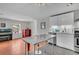 Open-concept kitchen boasts sleek white cabinetry, stainless steel appliances, and a modern island with bar stools at 4445 Old Park Rd, North Charleston, SC 29405