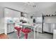 Modern kitchen with stainless steel appliances, sleek white cabinets, and a center island with red bar stools at 4445 Old Park Rd, North Charleston, SC 29405