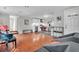 Open-concept living room featuring hardwood floors, a piano, a modern kitchen, and ample natural light at 4445 Old Park Rd, North Charleston, SC 29405