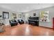 Airy living room with hardwood floors, comfortable seating, piano, lots of windows, and natural light at 4445 Old Park Rd, North Charleston, SC 29405