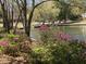 The pond's edge is adorned with vibrant pink azaleas, enhancing the scenic view and natural beauty at 4445 Old Park Rd, North Charleston, SC 29405