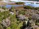Aerial view of waterfront properties amid lush trees and marshland under a partly cloudy sky at 5010 Timber Race Crse, Hollywood, SC 29449