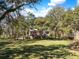 A tranquil backyard featuring mature trees, lush green space, and a glimpse of the home at 5010 Timber Race Crse, Hollywood, SC 29449