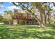 Expansive backyard with a large deck, screened porch, mature trees and lush greenery at 5010 Timber Race Crse, Hollywood, SC 29449