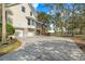 Home featuring an attached garage and spacious driveway surrounded by mature trees at 5010 Timber Race Crse, Hollywood, SC 29449