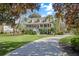 Beautifully landscaped property featuring a classic two-story home with mature trees and a long driveway at 5010 Timber Race Crse, Hollywood, SC 29449