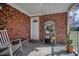 Covered porch with brick exterior, featuring a seating area and storage shelves at 503 Amberjack Way, Summerville, SC 29485