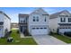 Two-story home featuring light gray siding, a white garage door and green lawn at 509 Purple Finch Rd, Summerville, SC 29486