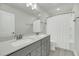 Modern bathroom with a double sink vanity and a shower with a white shower curtain at 5115 Cranesbill Way, Johns Island, SC 29455