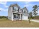 Charming two-story home featuring gray siding, black shutters and a two-car garage at 5115 Cranesbill Way, Johns Island, SC 29455