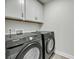 Bright laundry room with gray cabinets, modern machines and tile floor at 5115 Cranesbill Way, Johns Island, SC 29455