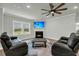 Comfortable living room with black leather seating, TV, fireplace, and a ceiling fan at 5115 Cranesbill Way, Johns Island, SC 29455