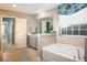 Elegant bathroom boasts a soaking tub, a large window, and a vanity with ample storage space at 523 Verdi Dr, Summerville, SC 29486