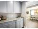 Butler's pantry featuring gray cabinets, granite countertops, and a view into the dining room at 523 Verdi Dr, Summerville, SC 29486