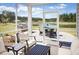 A screened patio featuring a complete outdoor kitchen and a view of a lake in a luscious green backyard at 523 Verdi Dr, Summerville, SC 29486