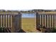 Backyard fence gate overlooks a tranquil pond, offering a serene view and outdoor enjoyment at 538 Spanish Wells Rd, Summerville, SC 29486