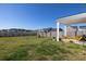 Spacious backyard with a covered patio, yellow chairs, lush lawn, and picturesque views of the pond at 538 Spanish Wells Rd, Summerville, SC 29486