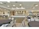 Large event space with round tables and chairs and an elevated stage area with a projector screen at 572 Tidewater Chase Ln, Summerville, SC 29486