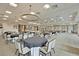 Large event space with round tables, chandelier lighting, neutral carpet, and stage area at 572 Tidewater Chase Ln, Summerville, SC 29486