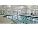 Bright indoor pool with lane markers, hot tub, floor to ceiling windows and doors leading outside at 572 Tidewater Chase Ln, Summerville, SC 29486
