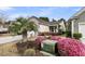 Home exterior shows charming landscaping with pink shrubs, a palm tree, and a well-manicured lawn at 614 Battery Edge Dr, Summerville, SC 29486