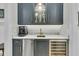 Stylish wet bar with brass fixtures, wine refrigerator, and storage for glassware at 740 Stucco Ln, Mount Pleasant, SC 29464