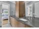 Modern bathroom boasts dual sinks, wood cabinetry, and a large mirror reflecting the bedroom view at 740 Stucco Ln, Mount Pleasant, SC 29464