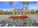Clubhouse with a flower bed in the foreground and palm trees surrounding it on a sunny day at 740 Stucco Ln, Mount Pleasant, SC 29464