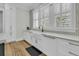 Bright kitchen sink with farmhouse style basin, quartz countertops and hardwood floors at 740 Stucco Ln, Mount Pleasant, SC 29464