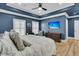 Main bedroom featuring a dark accent wall, tray ceiling and hardwood floors at 740 Stucco Ln, Mount Pleasant, SC 29464