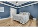 Bedroom with blue accent walls, hardwood floors and an ensuite bathroom at 740 Stucco Ln, Mount Pleasant, SC 29464