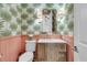 Charming powder room boasts palm wallpaper, wainscoting, and a unique vanity at 740 Stucco Ln, Mount Pleasant, SC 29464