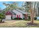 Charming single-story home featuring a well-manicured lawn, complemented by vibrant red shutters and a brick-accented garage at 8095 Old London Rd, North Charleston, SC 29406