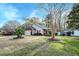 Charming home with red accents, two-car garage, front yard, mulch beds, grass and palm trees at 8095 Old London Rd, North Charleston, SC 29406